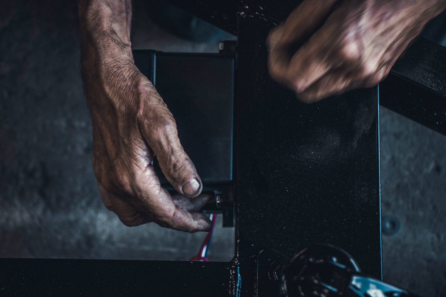 Renkli kabloları bir elektrik bileşenine bağlayan eller.